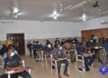 Officers of the Ghana Police Service seated in an examination hall or training setting